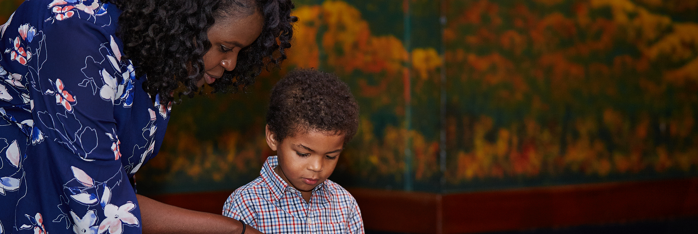A woman and her son in front looking down at an exhibit.