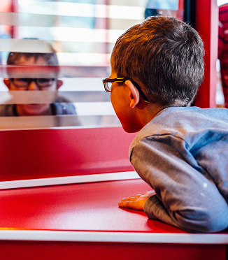 A young boy stares at his reflection.