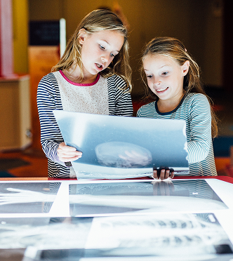 Two girls interact with the BodyWorks exhibit at the Kamin Science Center.
