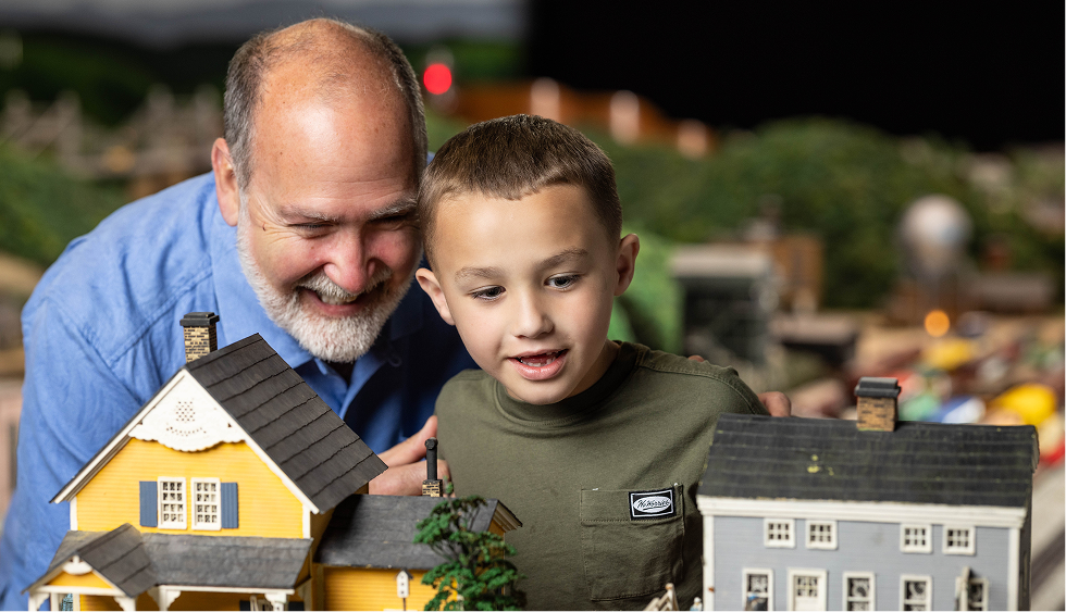 Grandfather and grandson looking at miniature display