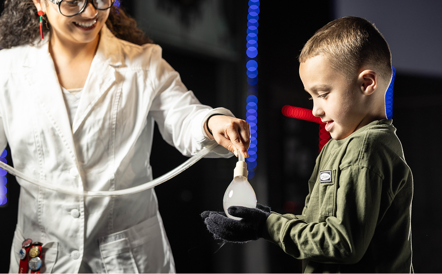 Science Center volunteer conducting demonstration with a child