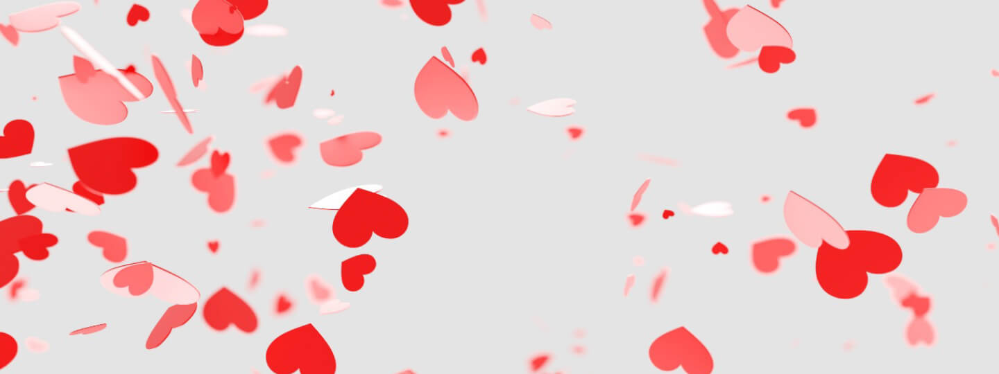 Confetti hearts in front of a gray background.