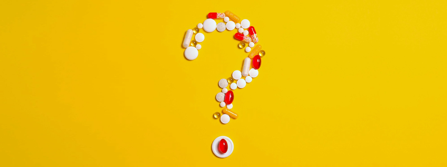 Question mark formed by various pills over a yellow background.