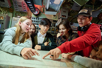 Guests pointing to a map on the USS Requin